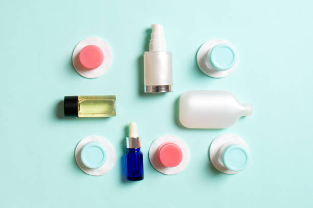 istock Group of small bottles for travelling on colored background. Copy space for your ideas. Flat lay composition of cosmetic products. Top view of cream containers with cotton pads 1286883636