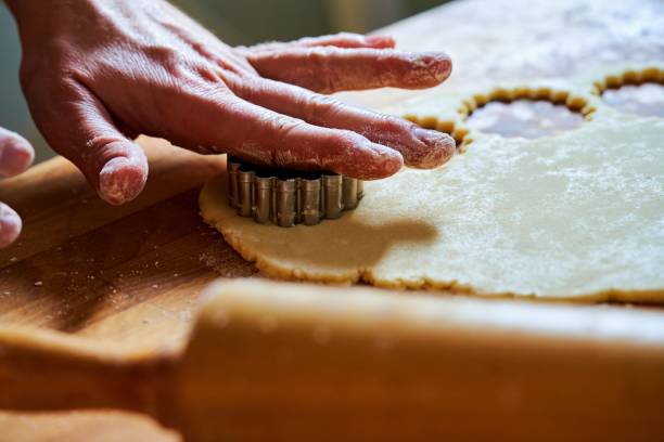 istock Hand with cookie cutter over rolled out dough and rolling pin 1286883928