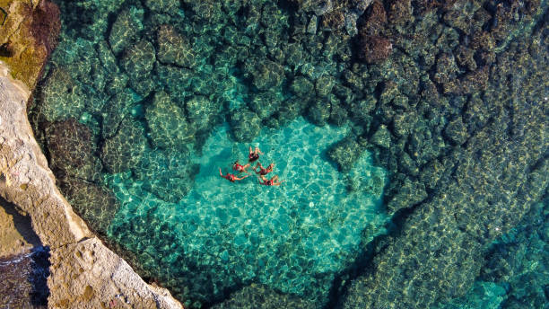 ragazze che nuotano sincronizzate in spiaggia a maiorca - synchronized swimming swimming sport symmetry foto e immagini stock