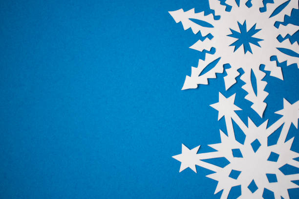 istock Handmade paper snowflakes on blue background 1286889668