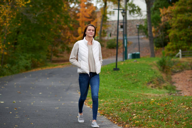 istock Cute young woman among fall foliage on campus 1286889765