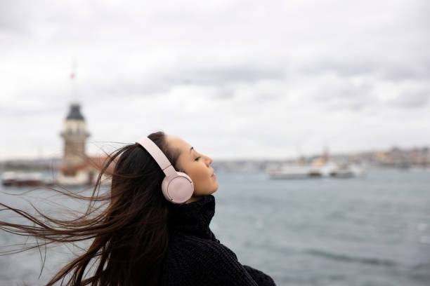 Beautiful woman listening to music with headphones in istanbul Maiden's Tower in Istanbul TURKEY maidens tower turkey photos stock pictures, royalty-free photos & images