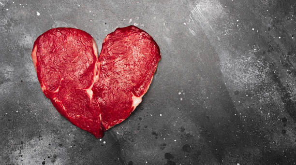 forma de corazón filete de carne fresca crudo sobre fondo oscuro con espacio para texto, vista superior - meat raw beef love fotografías e imágenes de stock
