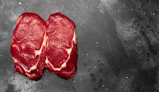 istock Ribeye fresh raw beef steak on dark background with space for text, top view, flat lay 1286892663