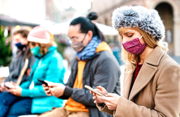 istock Blond girl using smart phone covered by mask on Covid second wave - New normal lifestyle concept with milenial people watching video on mobile smartphone - Vivid filter with focus on woman face 1286895929