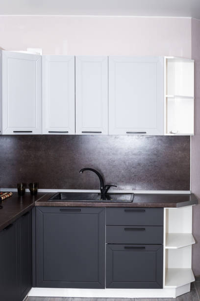 istock kitchen with brown countertop and black sink, light gray cabinet drawers. Kitchen interier 1286896057