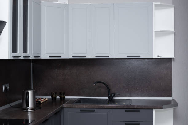 istock kitchen with brown countertop and black sink, light gray cabinet drawers. Kitchen interier 1286896106