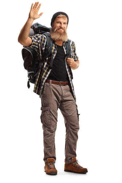 カメラに手を振るバックパックを持つひげを生やした男のハイカー - travel vacations studio shot vertical ストックフォトと画像