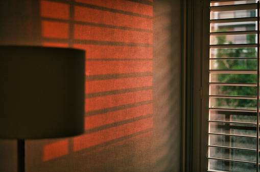 sun rising through hotel window shutters