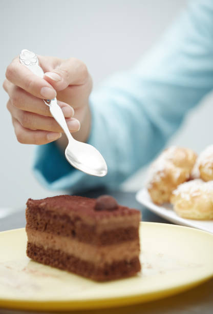 istock Hand of woman eating chocolate cake 1286903110