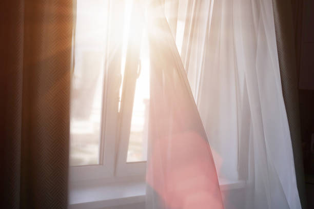 istock bright sunrays light through white textile curtain illuminating room of apartment 1286903127