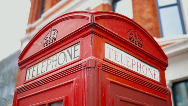 Top of a London telephone booth with a blurry brick building as background