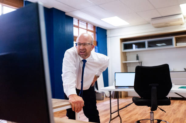 istock Male office employee standing looking at screen squinting to see. 1286904813