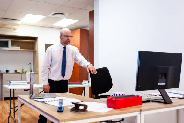 istock Goofy office employee standing looking at screen as his hand slips and he falls 1of3 1286904838