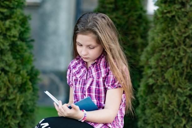 istock A 10 years old girl sitting and reading a book. 1286905549