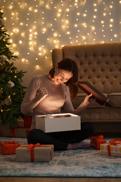 istock Happy beautiful woman opening a gift 1286906749