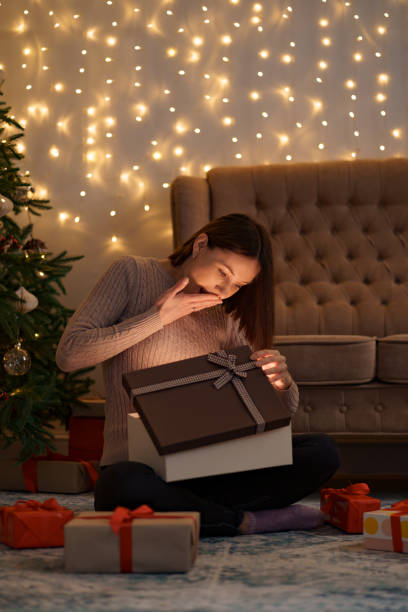 istock Happy beautiful woman opening a gift 1286906755