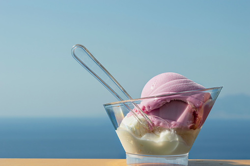 A bowl of various ice cream, isolated on a blue background of the sea. Macrophoto