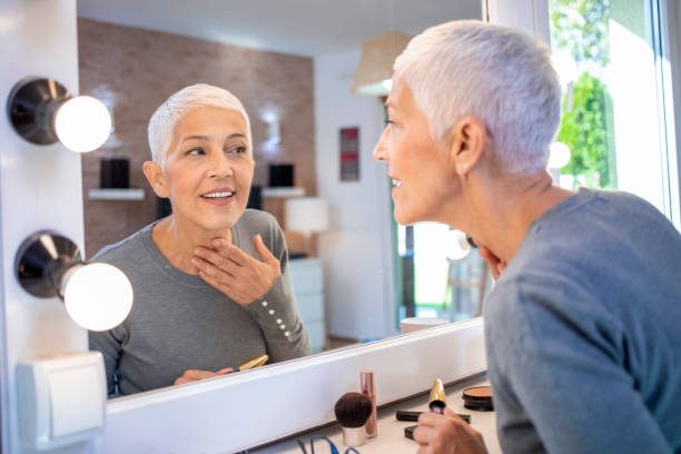 istock Beautiful mature woman looking at herself in the mirror. 1286914432