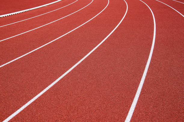 istock Curved white lines on a red running track 1286914689