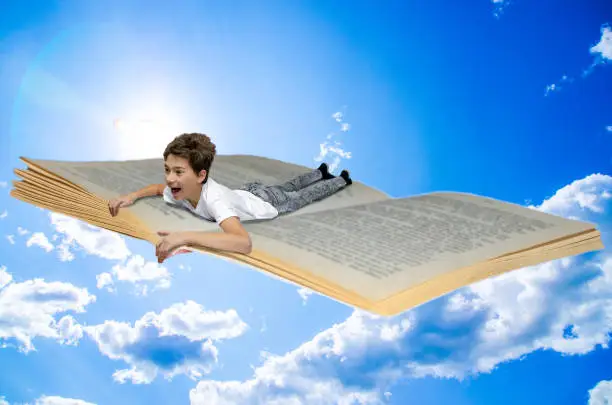 Photo of Boy flying on a book