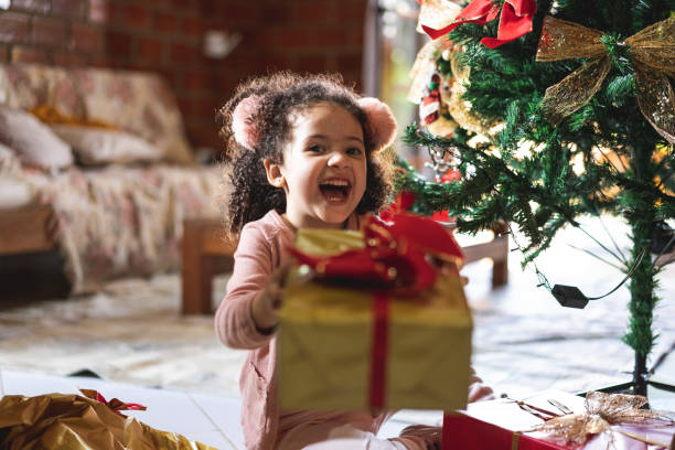 glückliches mädchen hält weihnachts-geschenk-box - 1 2 months stock-fotos und bilder