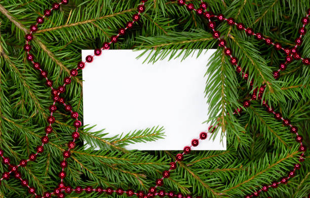 istock Creative layout made of Christmas tree branches and garlands with paper card note. Flat lay. Nature New Year concept. 1286917013