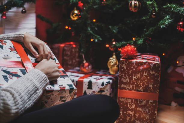 istock Beautiful young woman opens presents on Christmas night 1286918785