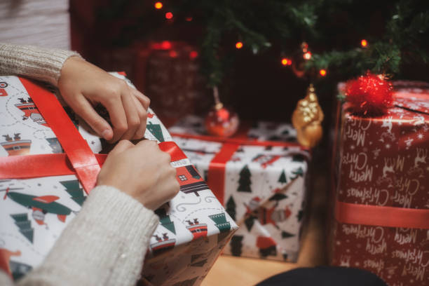istock Beautiful young woman opens presents on Christmas night 1286918803