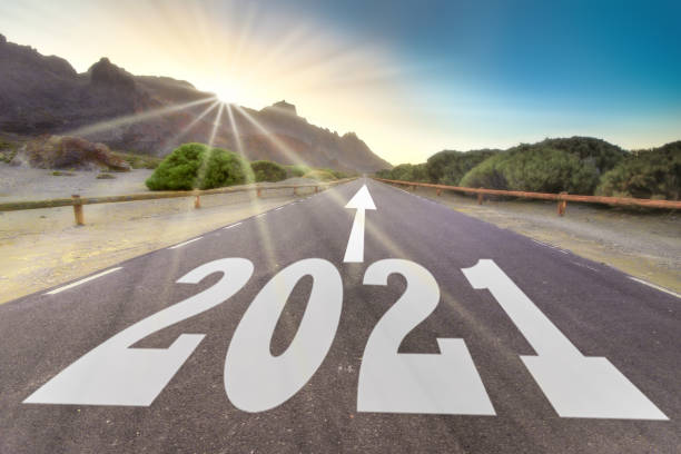 istock new year 2021 concept, empty asphalt road against the sunrise with sun rays 1286919576