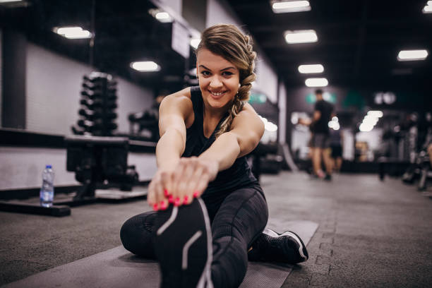 istock Fit woman doing warming up exercises in gym 1286921768