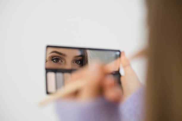 istock Reflection in a mirror of young woman applying eyeshadow 1286926370