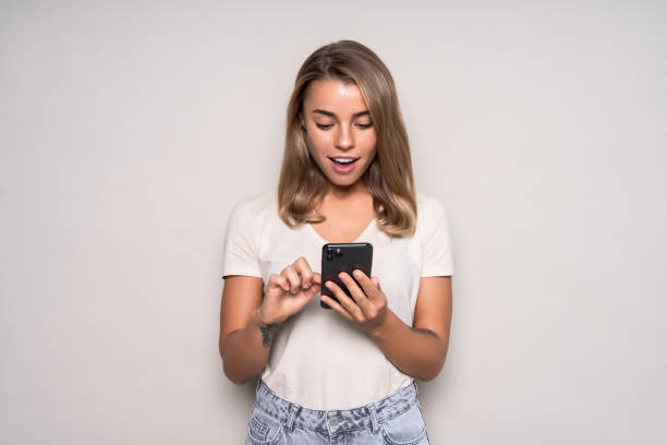 istock Beauty young woman using and reading a smart phone isolated on a white background 1286926638
