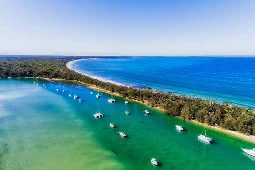 Curambene creek entering Jervis bay in Huskisson town on Australian Pacific coast - aerial summer time view.