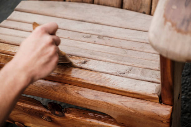 istock Applying Wood Preservative to Cedar Adirondack Chair 1286929643