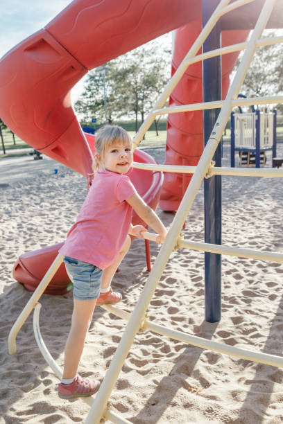 istock Active happy brave Caucasian girl child climbing staircase climber on playground schoolyard outdoors on summer sunny day. Seasonal kids activity outside. Authentic childhood lifestyle concept. 1286929708