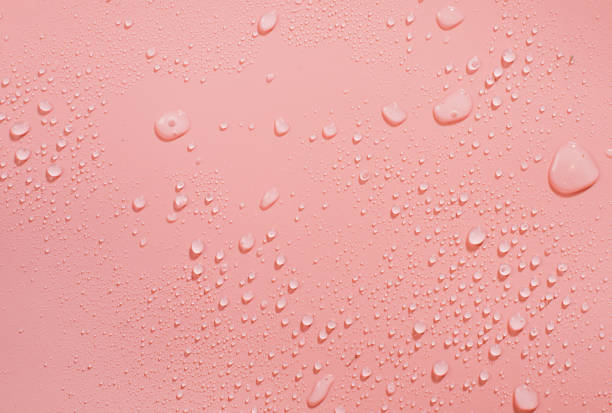 istock Drops of water on a color background. Pink. Selective focus. Toned. 1286930013