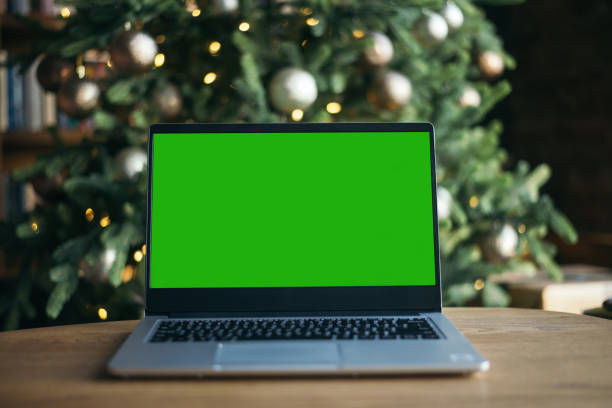 vista frontale del laptop con schermo verde sullo sfondo dell'albero di natale. aiuto con le nuove tecnologie. isolamento a casa secondo il concetto di coronavirus. freelance. - green tree monitor foto e immagini stock