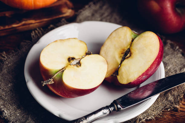 istock Two Halves of Red Apple on White Plate 1286931609