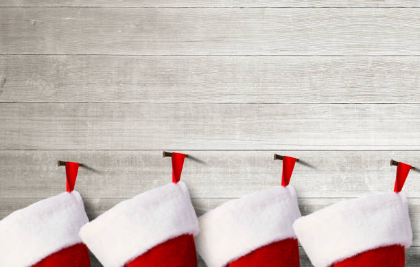 istock Four Empty Christmas Stockings Hanging On A Wall 1286932516