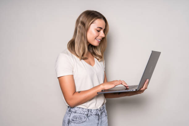 istock Beautiful young woman using laptop computer isolated on white background 1286935245