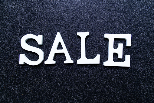 White letters SALE on black glitter background. black friday, cyber monday and seasonal sales banner