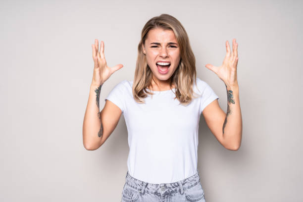 istock Young angry pretty woman screaming isolated on white background 1286937087