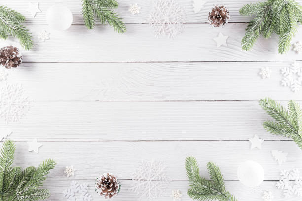 istock Christmas decor composition background. Christmas gift, pine cones, fir branches and snowflake on white wooden background. Flat lay, top view with copy space. 1286939759