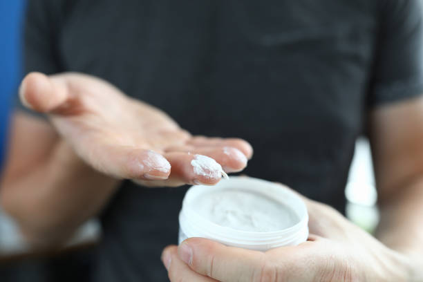 istock Man's hand holds jar with a white substance inside. 1286940843