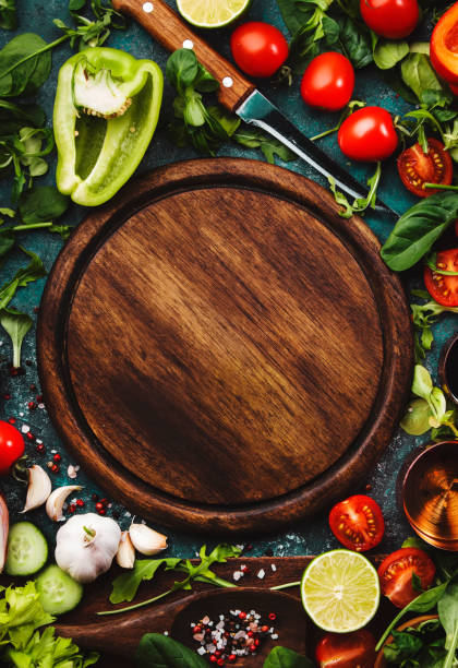 istock Fresh helthy food cooking vegetable ingredients on dark background with rustic wooden board. Diet or vegetarian food concept. Top view, copy space 1286940942