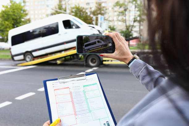 Woman insurance agent films broken minibus on smartphone Woman insurance agent films broken minibus on smartphone. Comprehensive vehicle insurance concept commercial land vehicle stock pictures, royalty-free photos & images