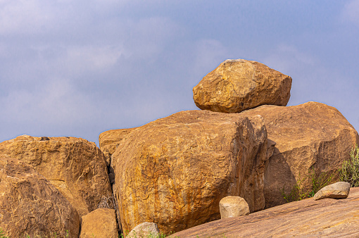 Krishnapura, Karnataka, India - November 4, 2013: Brown huge boulders near  Sasivekaly Ganesha or Mustard Seed statue under blue sky.