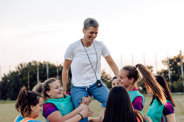 istock Female rugby team celebrating success with their coach 1286942563