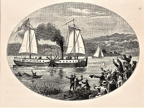 Steamboat, invented by Robert Fulton, sailing on the Hudson River while people cheer from shore. American history. Illustration published in First Lessons in Our Country’s History by William Swinton, A.M. (Ivison, Blakeman, Taylor, & Company, New York and Chicago) in 1872.
